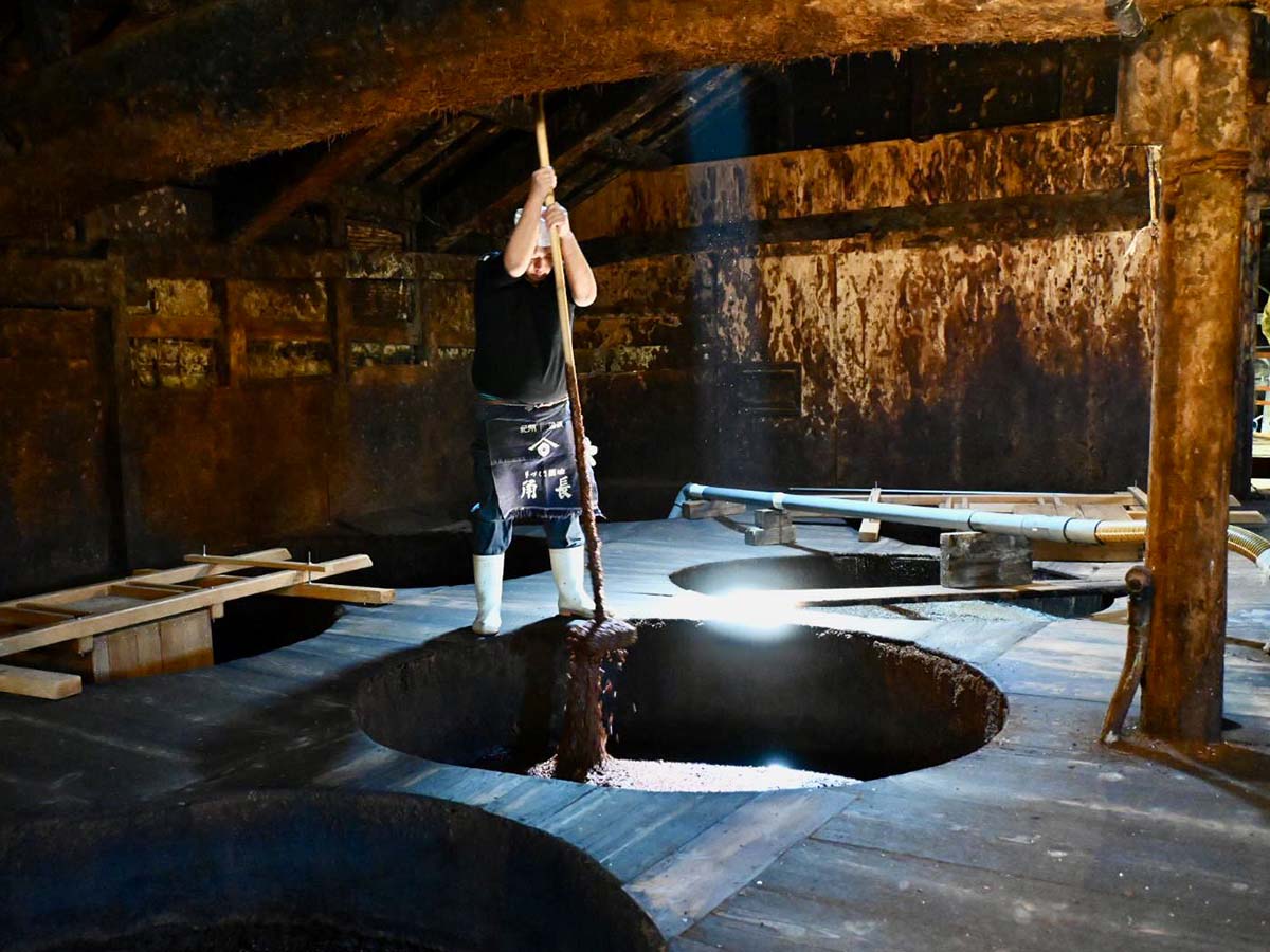 ▲仕込み桶で醸されるもろみは、発酵の度合いに合わせて人の手で底から撹拌する。重労働だ
