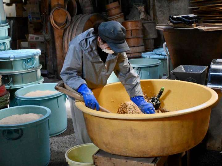 ▲麹づくりのため穀物を混ぜる智子さん