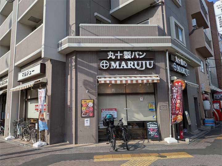 ▲十字の紋章が映える「丸十製パン」。駅近活気あふれる店構え